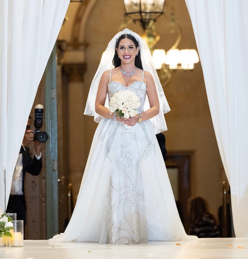 A Belle Massacre Affair. Our first wedding Belle in a flowing masterpiece adorned with diamond beaded detail, a dreamy detachable train, capturing the enchanting essence of her fairy tale moment. 